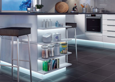 Îlot de cuisine blanc moderne avec étagères éclairées, tabourets noirs et sol carrelé gris