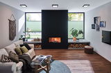 Modern living room with black fireplace, wooden floor and green pleated blinds for cozy lighting.