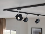 Black LED spotlight system with three adjustable lights on black track for modern room lighting