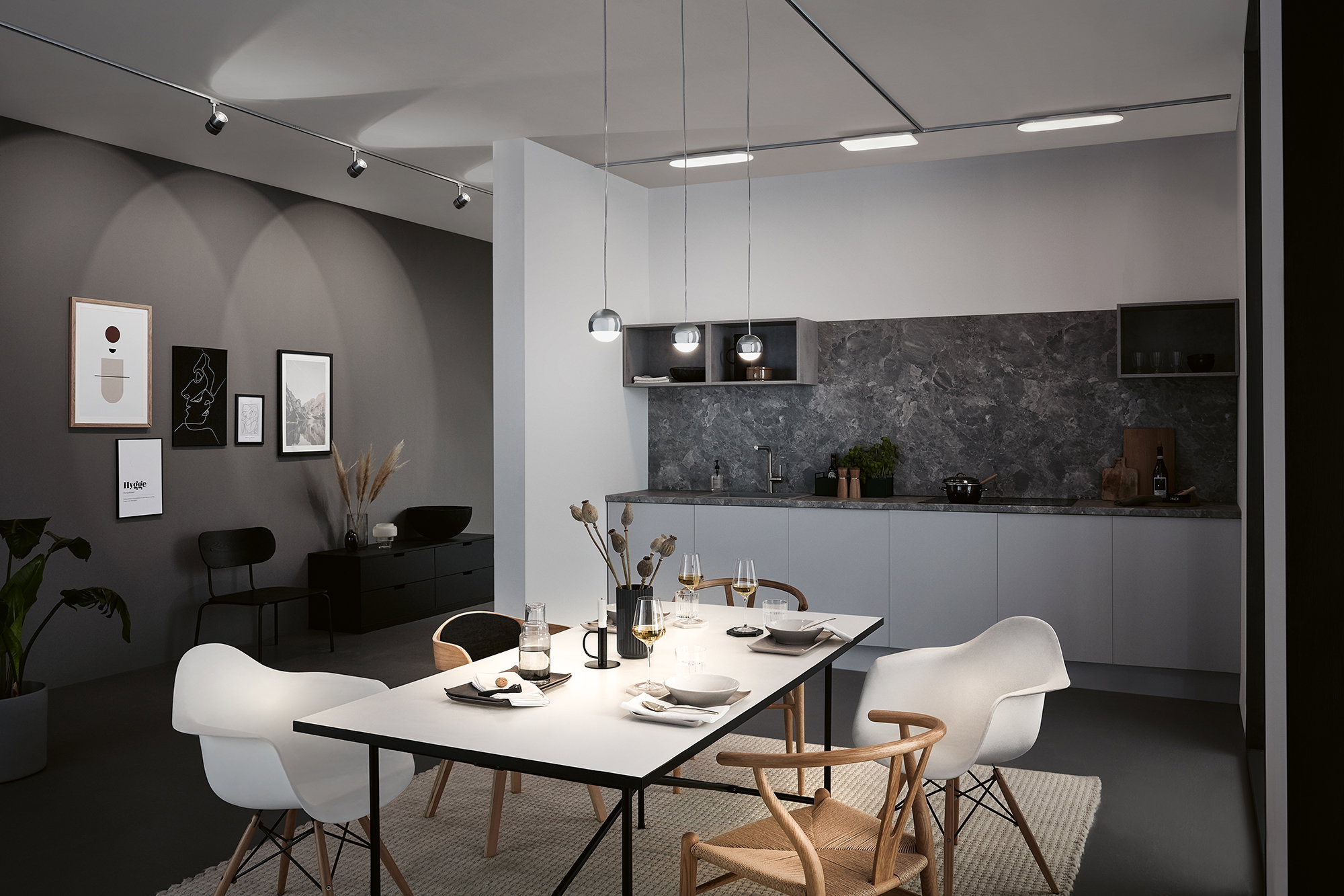 Modern kitchen with grey marble countertop, white cabinets, pendant lights and ceiling spotlights