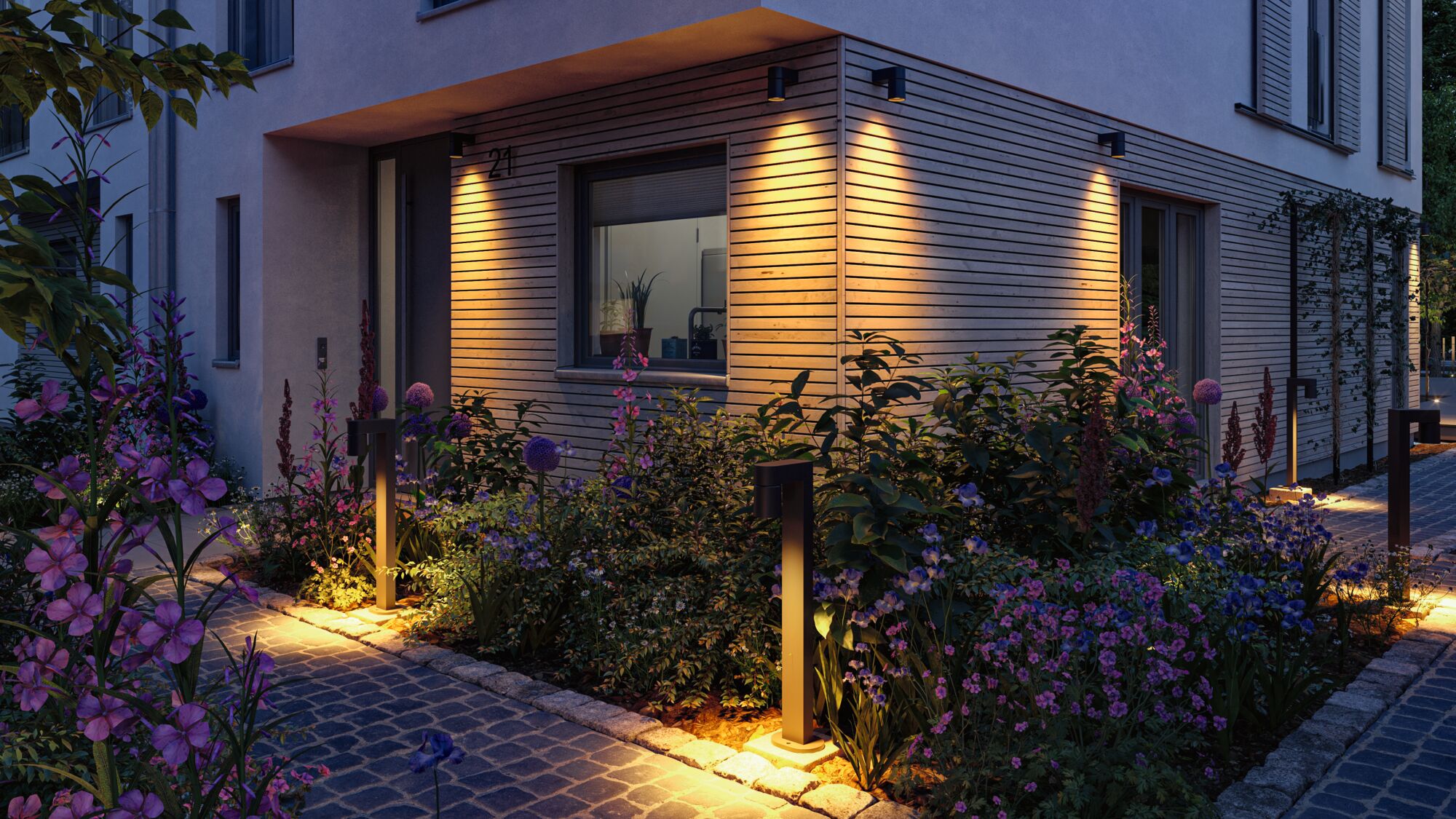 Moderne Außenbeleuchtung mit warmweißen LED-Wandleuchten und Pollerleuchten an Hausfassade und Gartenweg