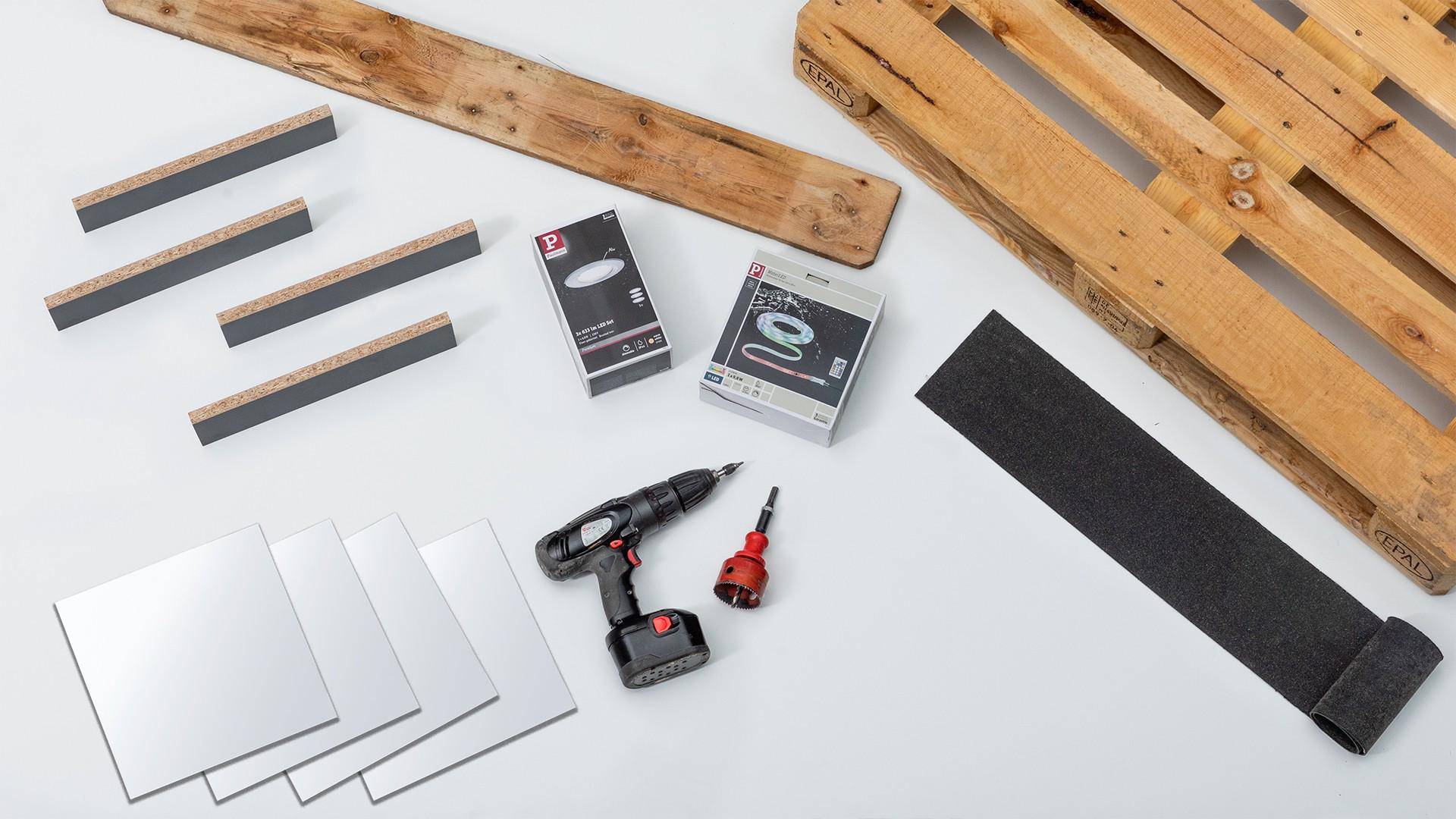 Tools and LED lighting with wooden boards and black felt for DIY shelf construction on white background