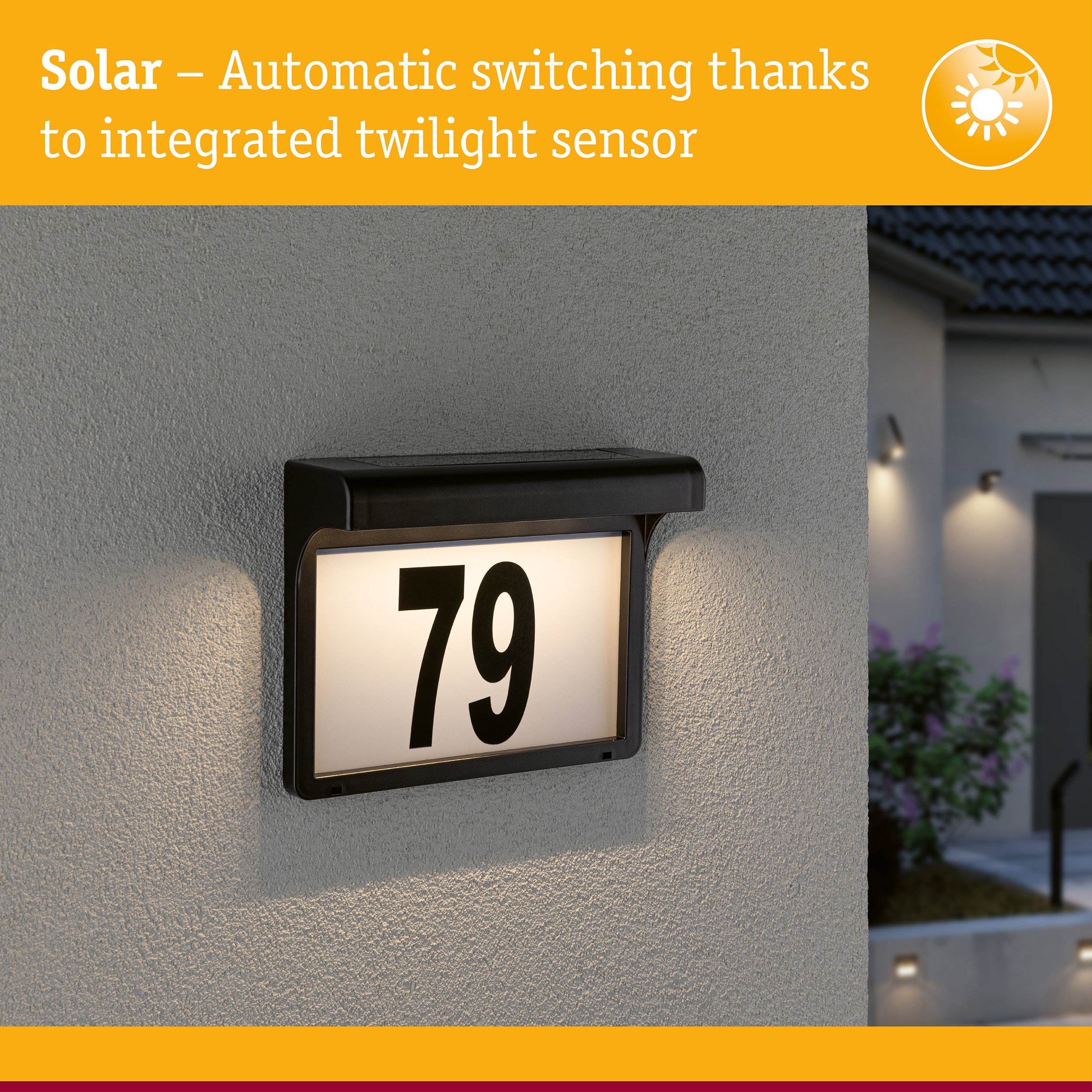 Black solar house number sign with integrated twilight sensor lighting on grey wall