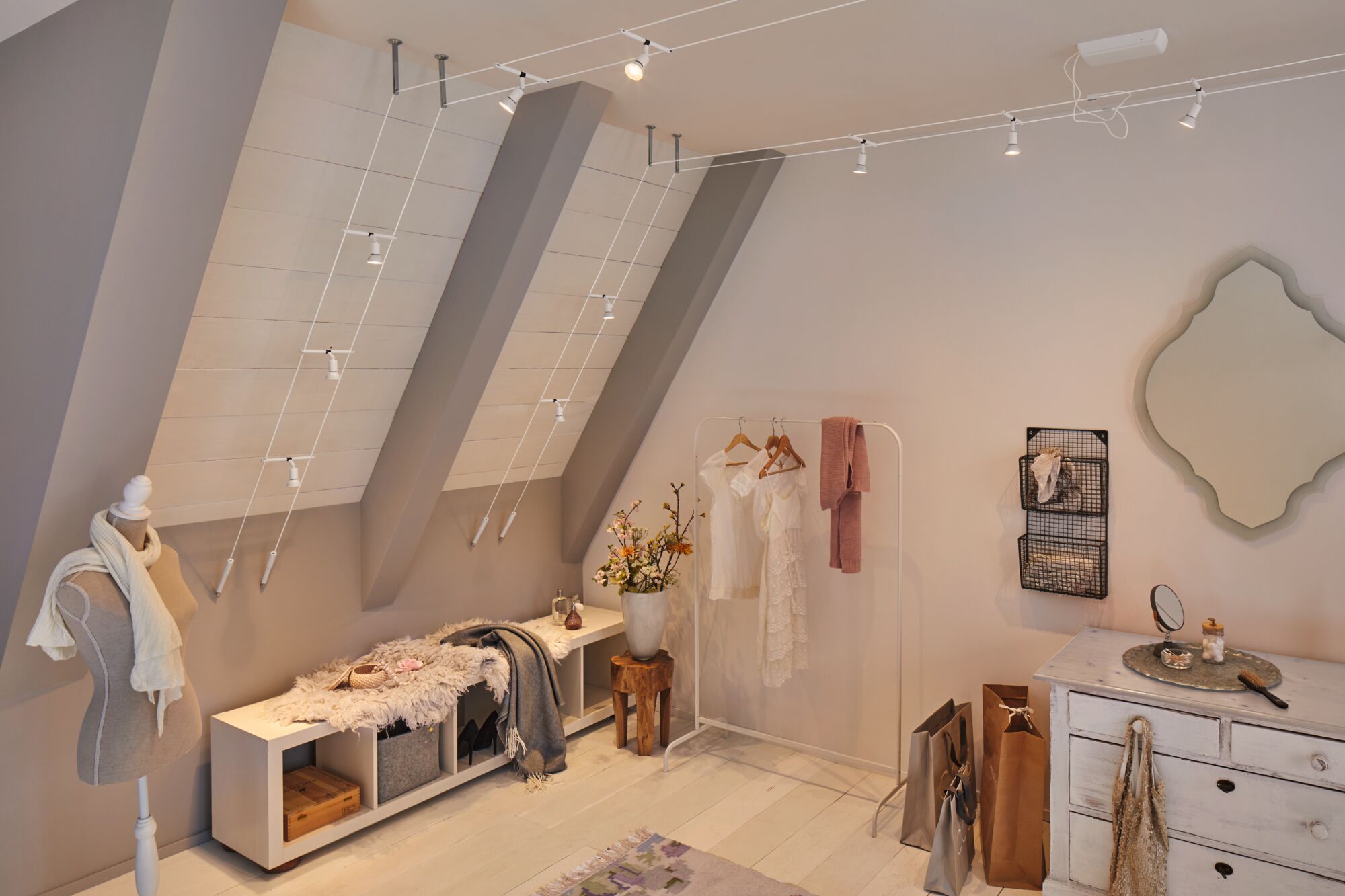 Weißes Seil-Lichtsystem mit verstellbaren Spots an schräger Decke in modernem Ankleidezimmer