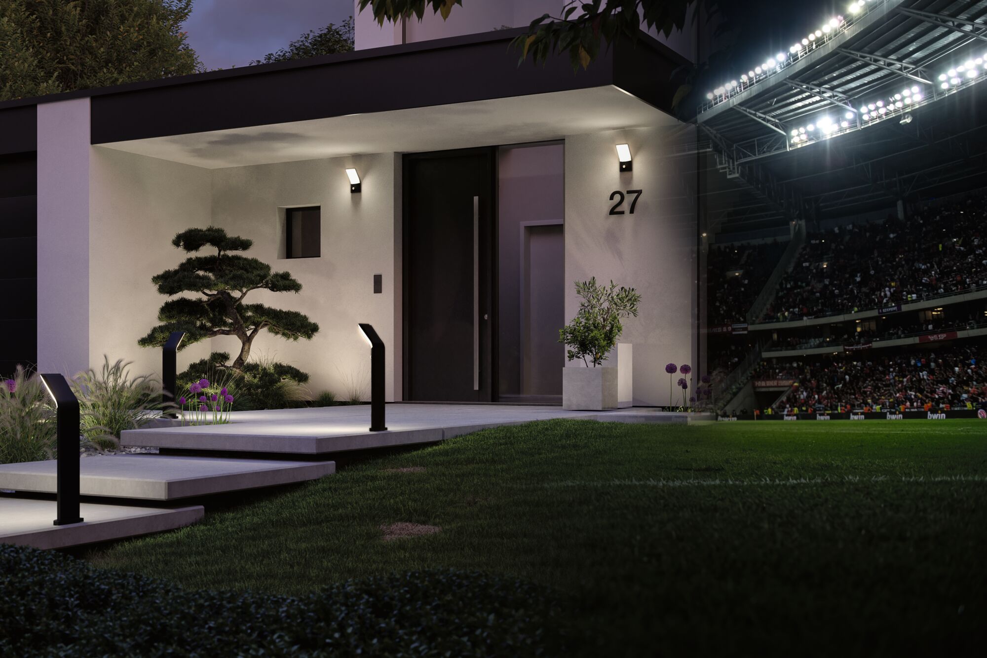 Modernes Haus mit schwarzer Tür und Außenbeleuchtung aus schwarzem Metall und weißem Licht