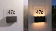 Black solar LED house number sign with clear acrylic plate showing number 47c on white wall