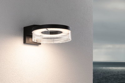 Modern black LED wall light with round acrylic glass and warm white light for outdoor use