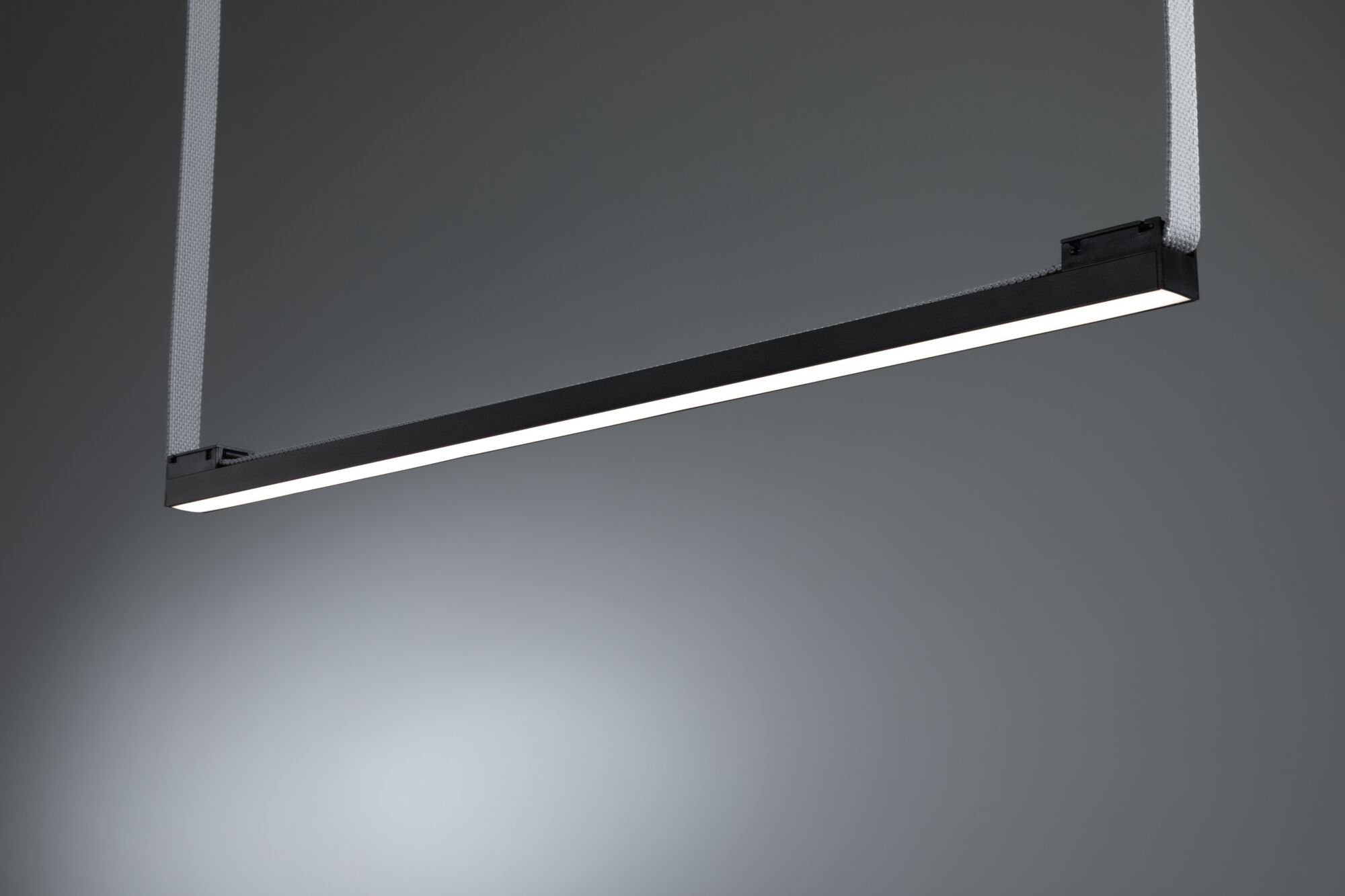 Black LED pendant light with white light strip and fabric suspension for modern interiors.