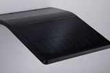 Schwarzes, gebogenes Solarpanel mit feinen Linien auf glatter Oberfläche für nachhaltige Energie.