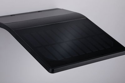 Black curved solar panel with fine lines on smooth surface for sustainable energy solutions.