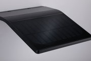 Schwarzes, gebogenes Solarpanel mit feinen Linien auf glatter Oberfläche für nachhaltige Energie.