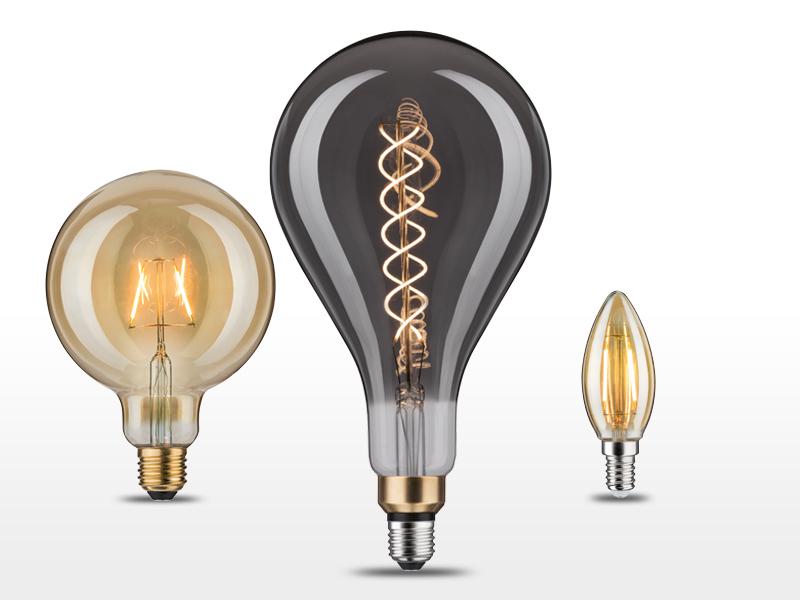 Tre dekorative LED-pærer i forskellige former med varmt rav- og røgfarvet glas til stemningsbelysning.