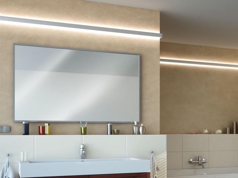Moderne badkamer met grote rechthoekige spiegel en warm wit LED-wandlicht voor stijlvolle badkamervormgeving.