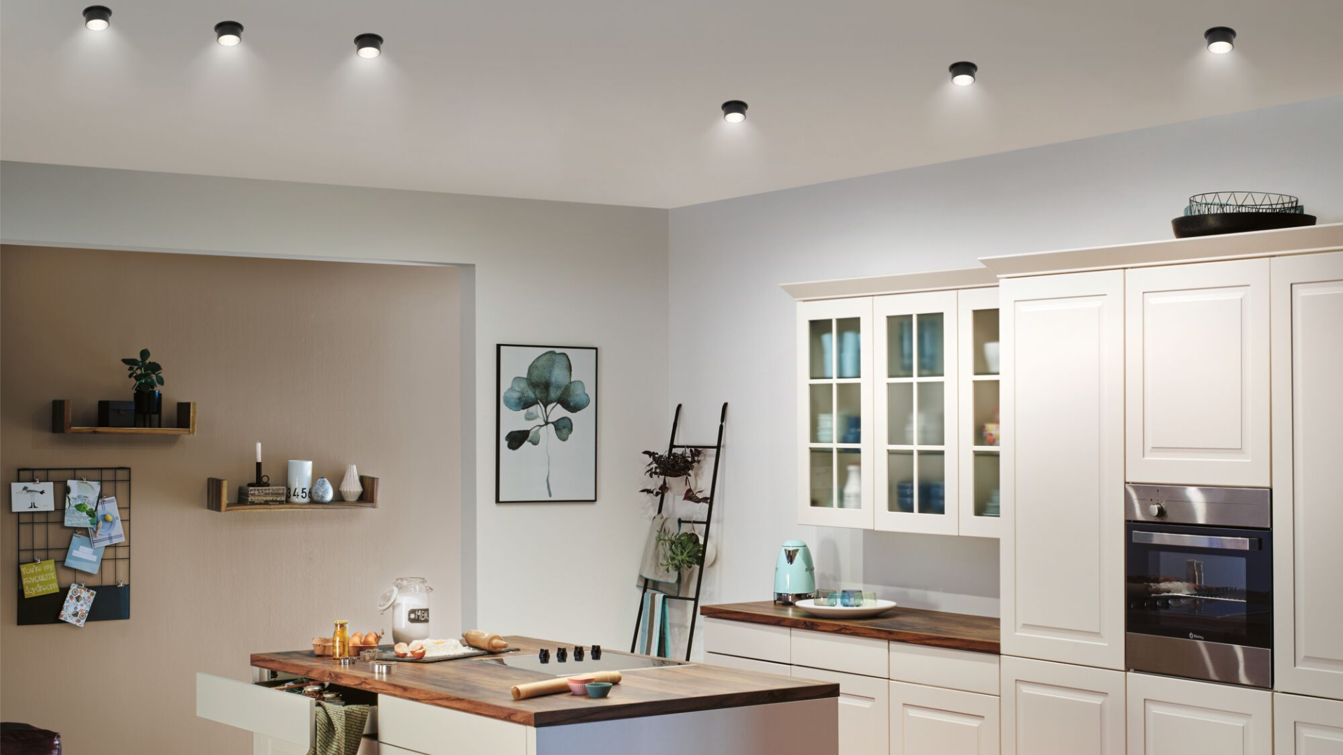 Modern kitchen with white wooden cabinets, wooden countertop and black ceiling lights for ambient lighting