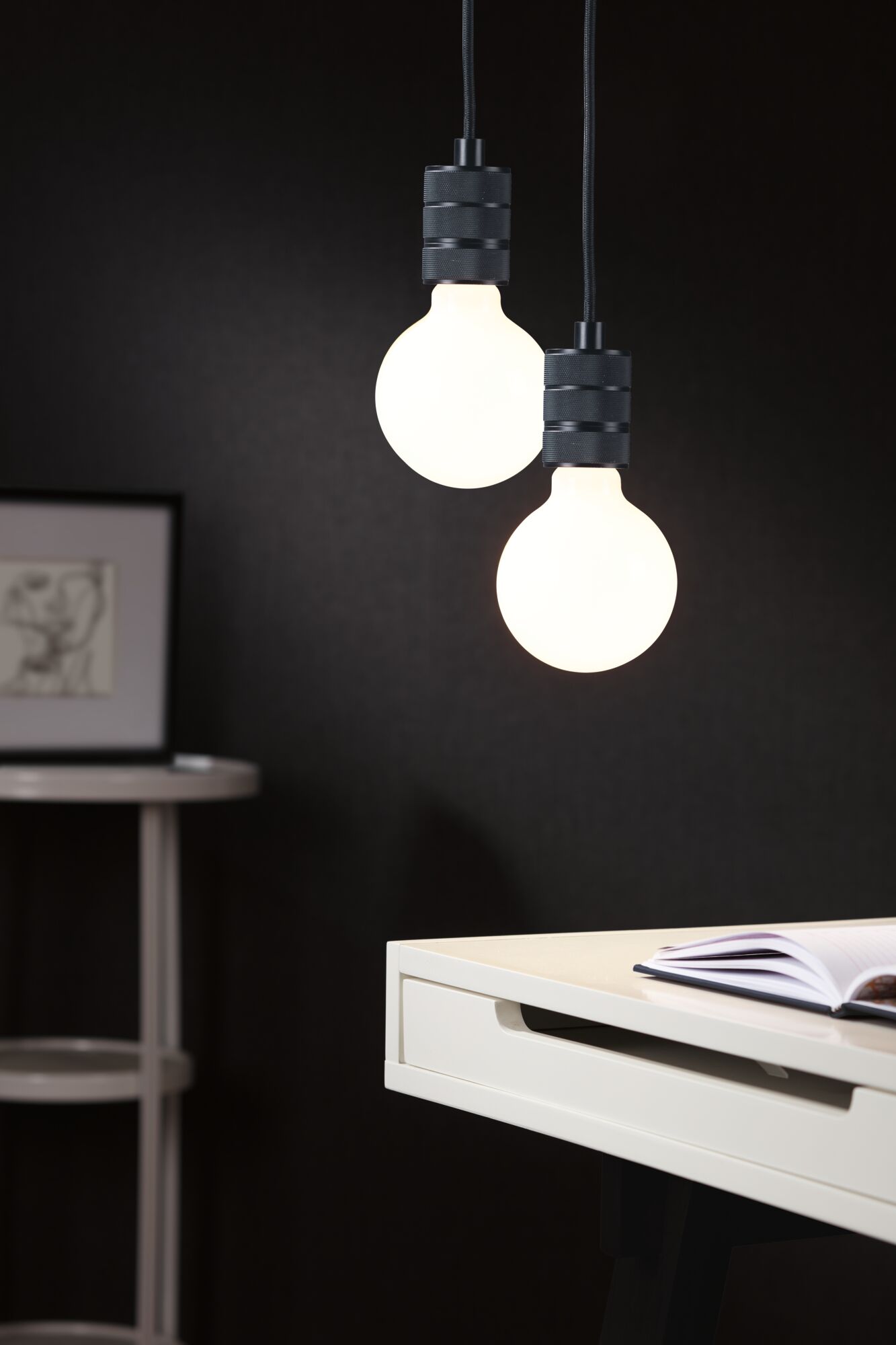 Two hanging LED bulbs with matte black fittings against dark background in modern interior lighting