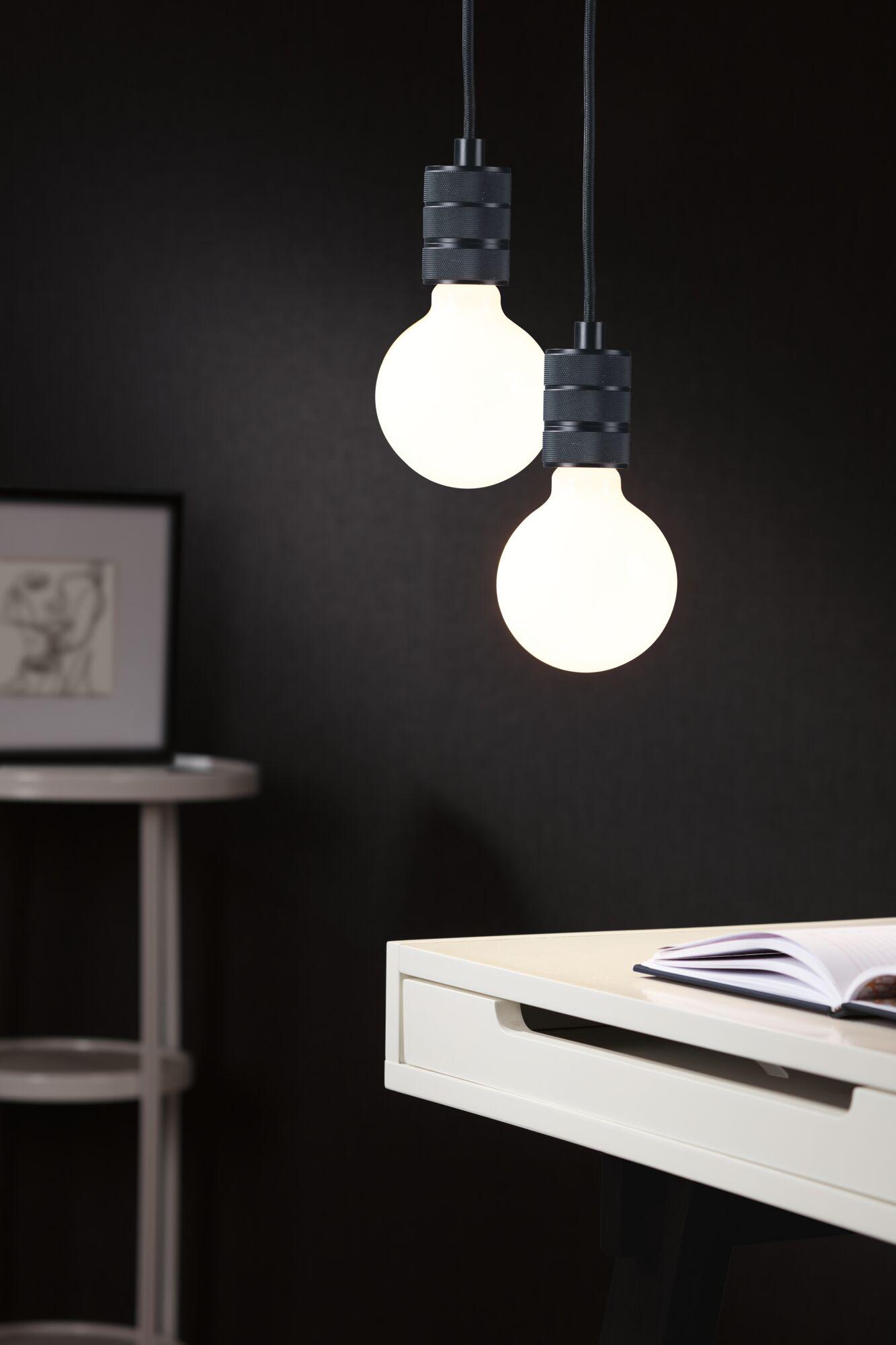 Two hanging LED bulbs with matte black fittings against dark background in modern interior lighting