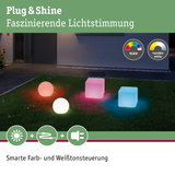 Bunte Plug & Shine LED-Leuchten in Kugel- und Würfelform auf Rasen mit RGBW und Weißtonsteuerung