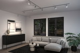 Modern living room with grey fabric sofa, black sideboard and adjustable metal ceiling spotlights.