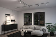 Moderner Wohnraum mit grauem Stoffsofa, schwarzem Sideboard und verstellbaren Deckenstrahlern aus Metall.