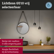 Moderne badkamer met ronde spiegel, zwarte hanglampen en houten plank met accessoires en planten