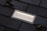 Rectangular stainless steel recessed light with warm white glow in dark pavement for outdoor lighting