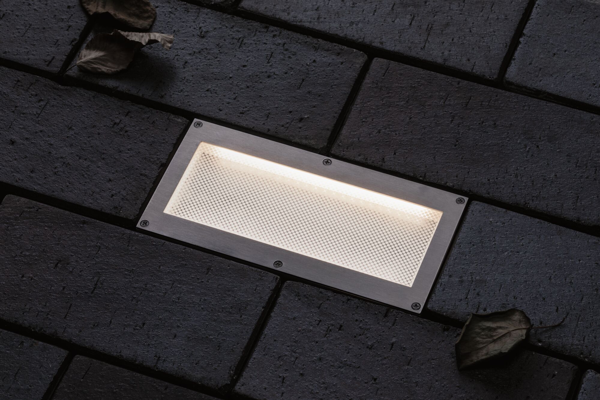 Rechthoekige LED-inbouwlamp van roestvrij staal in bestrating met warm wit licht