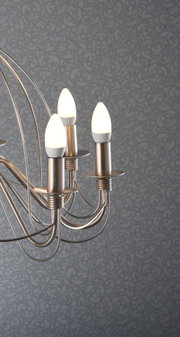 Modern brushed metal ceiling light with three warm white LED candle bulbs against patterned wall