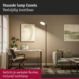 Zwarte staande lamp Caneta verlicht een moderne werkplek met bank en bureau in neutrale tinten