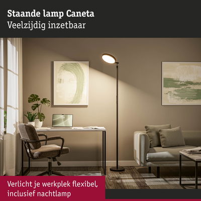 Zwarte staande lamp Caneta verlicht een moderne werkplek met bank en bureau in neutrale tinten