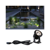 Schwarze LED-Teichleuchte mit Kabel, beleuchtet Wasserpflanzen und Seerosen in Gartenteich bei Nacht