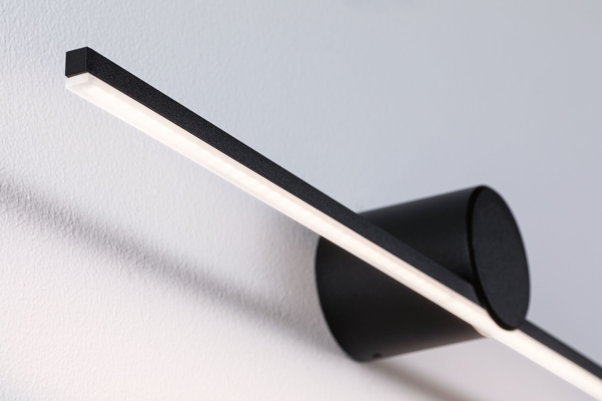 Schwarze LED-Wandleuchte aus Metall mit langem, schmalem Leuchtstab für modernes Wohnambiente