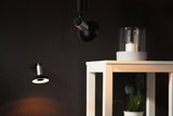 Black and silver LED wall and ceiling lights on dark wall with white table and candle decor