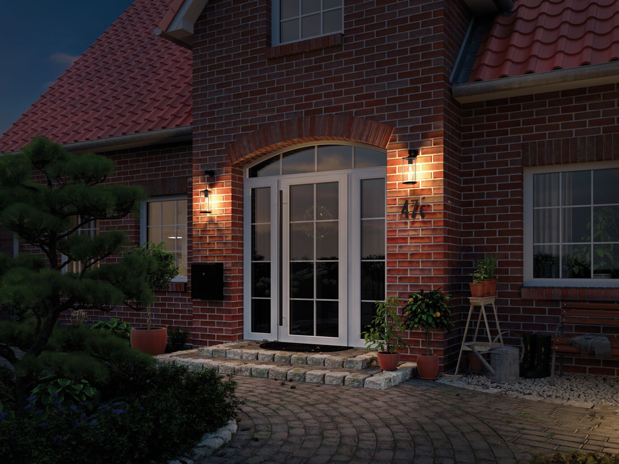 Illuminated house entrance with white glass doors and two black wall lamps on red brick.