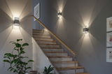 Modern grey metal wall light with decorative light pattern on staircase wall for indoor lighting