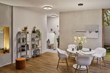 Moderner Essbereich mit weißem Tisch, Stühlen aus Kunststoff und Holz, LED-Deckenleuchten und Pendelleuchte.