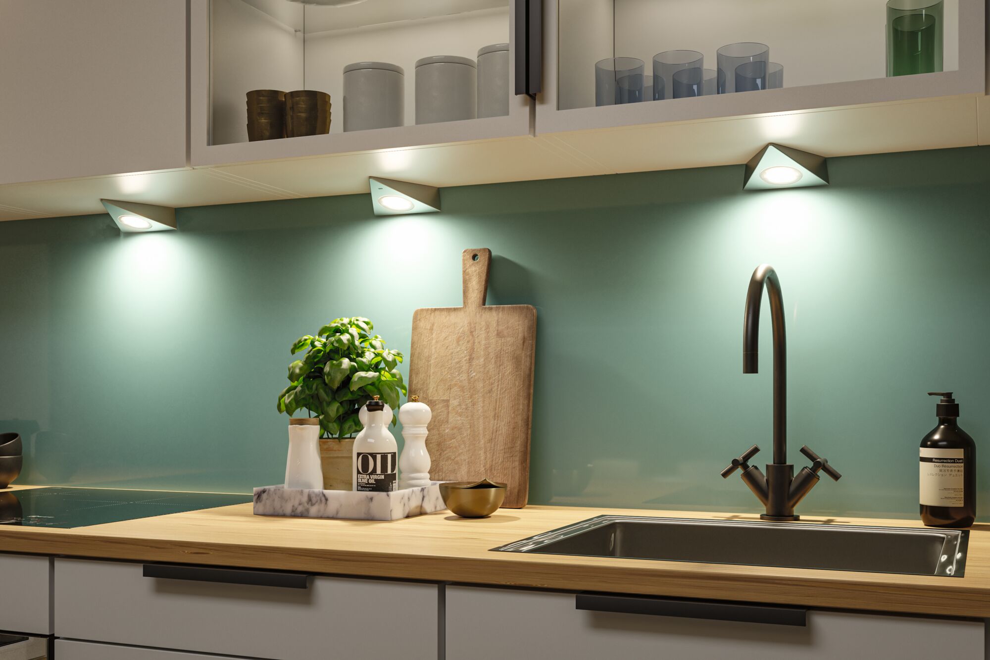 Plan de travail de cuisine moderne en bois avec évier en acier inoxydable et éclairage LED sous les meubles.
