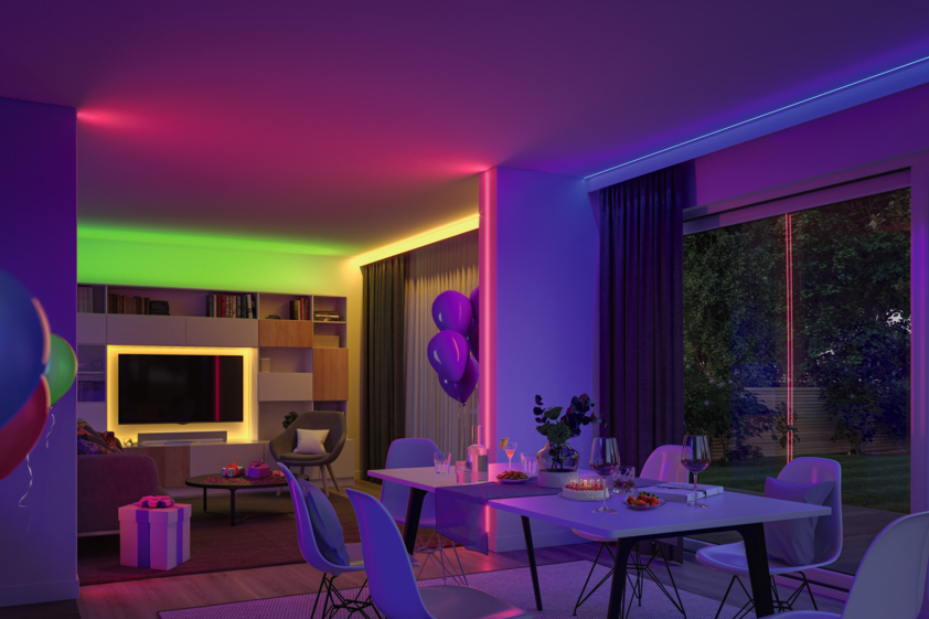 Living room illuminated with colorful LED strips in green, yellow, pink, and blue for ambient lighting.