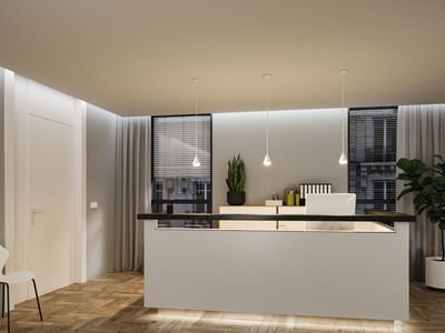 Bureau moderne avec comptoir d'accueil blanc, sol en bois et trois suspensions blanches en plastique.