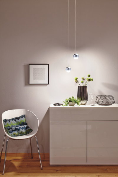 Moderne hvid højglans kommode med dekoration og to runde LED-pendellamper med varmt hvidt lys
