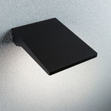 Schwarze Aluminium-Wandleuchte mit flachem Design und indirektem Licht für moderne Innenräume.