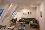 Modernes Wohnzimmer mit grünem Ecksofa, grauem Teppich und Paulmann LED-Seilstrahlern an der Decke.