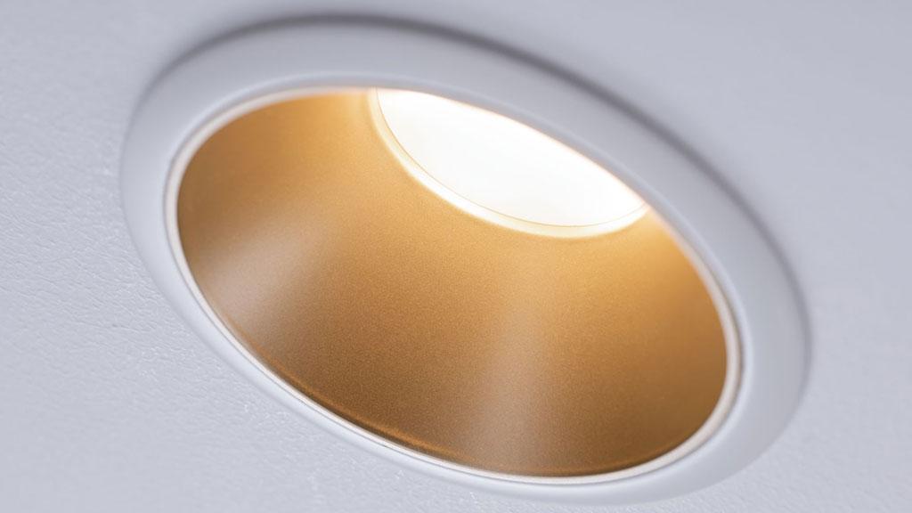 Weißer Einbaustrahler mit goldfarbener Reflektorfläche für moderne LED-Deckenbeleuchtung.