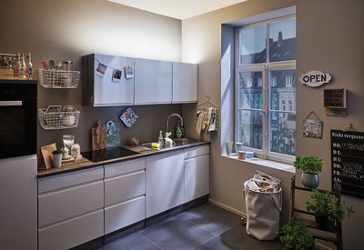 Moderne Küche mit weißen Fronten, Holzarbeitsplatte und indirekter LED-Beleuchtung für Wohnraumbeleuchtung.