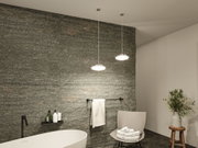 Moderne badkamerverlichting met twee ronde chromen LED-hanglampen tegen een grijze natuurstenen muur