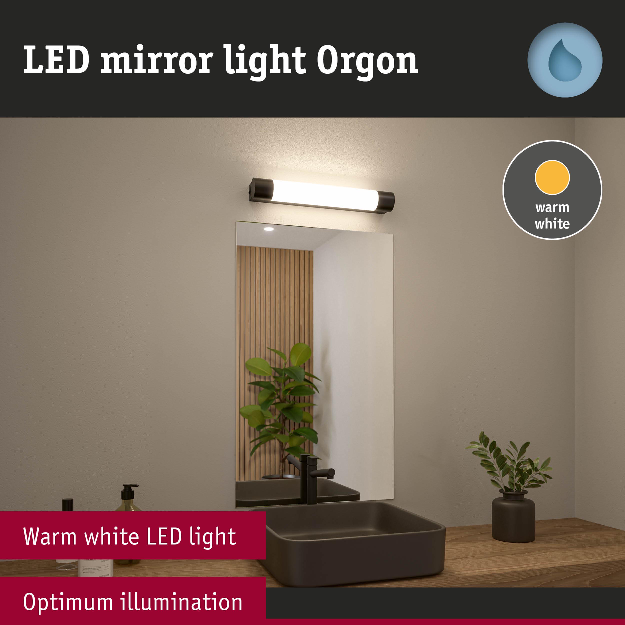 LED mirror light Orgon with warm white illumination above black sink on wooden countertop