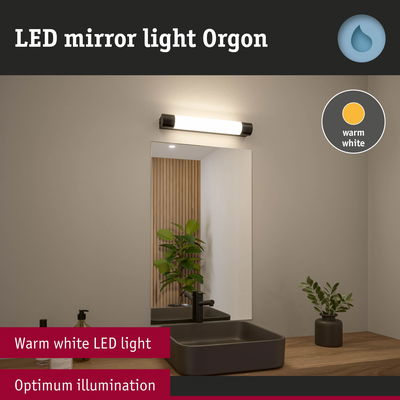 LED mirror light Orgon with warm white illumination above black sink on wooden countertop