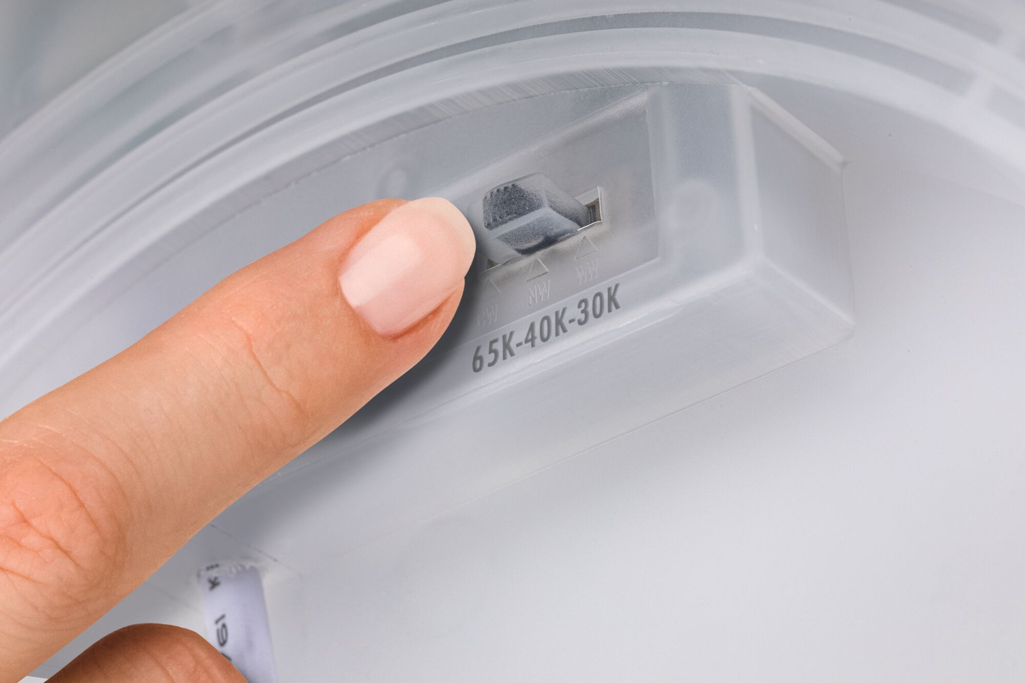 Finger justerer farvetemperaturkontakt 65K-40K-30K på hvidt plastbelysningsapparat