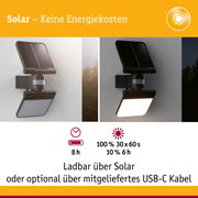 Schwarze Solarleuchte mit Bewegungssensor an Wand montiert, Tages- und Nachtansicht, energiesparende Außenbeleuchtung