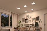 Modernes Esszimmer mit fünf quadratischen LED-Deckenleuchten in warmweißem Licht und Holzstühlen.