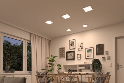 Modernes Esszimmer mit fünf quadratischen LED-Deckenleuchten in warmweißem Licht und Holzstühlen.